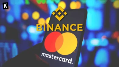 Binance logo on top of a phone with a Mastercard logo