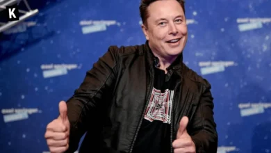 Elon Musk posing for a picture with thumbs up