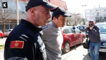 Do Kwon in handcuffs escorted by a Montenegrin police officer